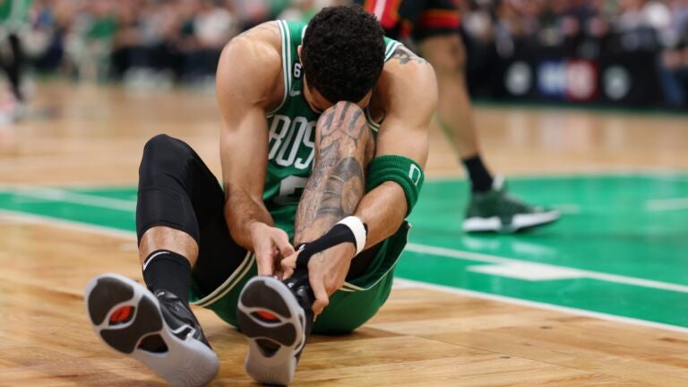 Jayson Tatum #0 of the Boston Celtics grabs his ankle during the first quarter against the Miami Heat in game seven of the Eastern Conference Finals at TD Garden on May 29, 2023 in Boston, Massachusetts.