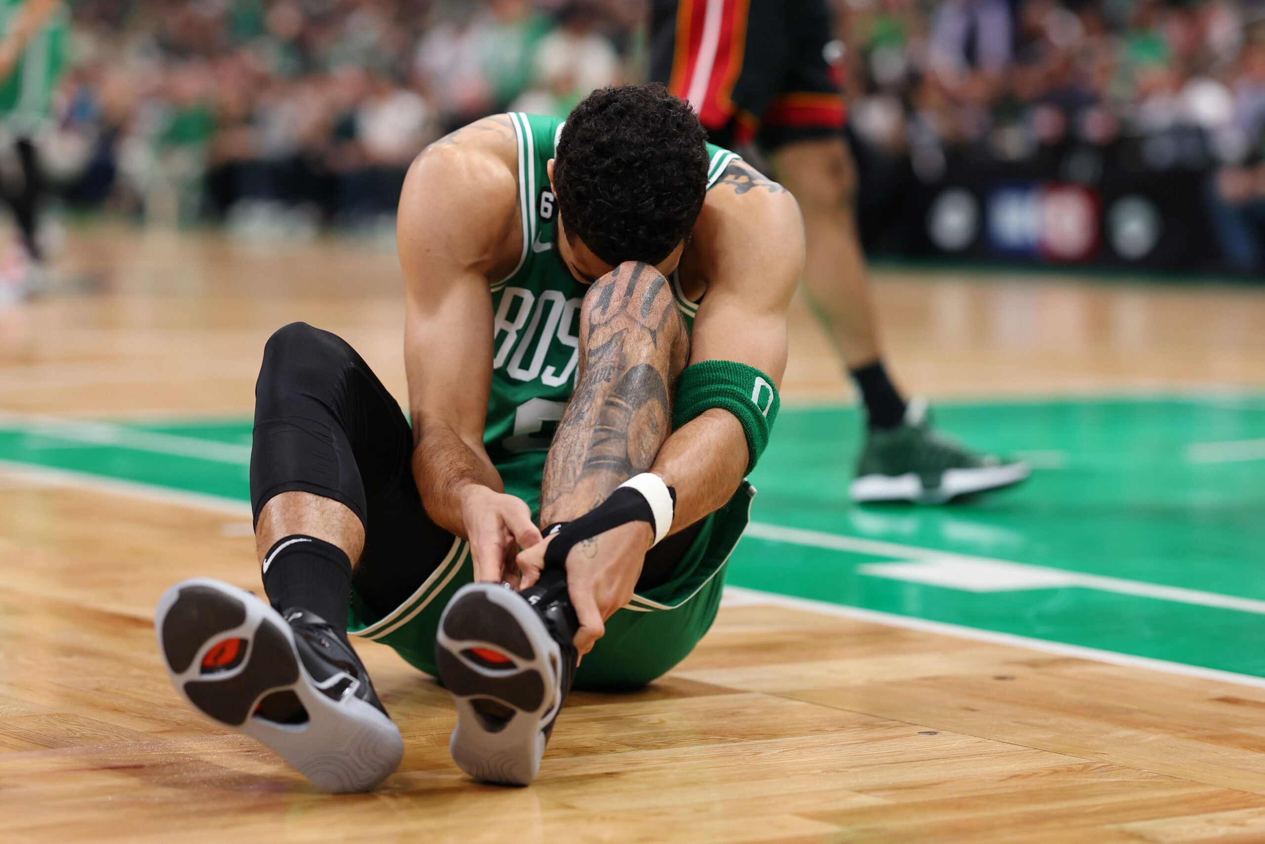 Jayson Tatum #0 of the Boston Celtics grabs his ankle during the first quarter against the Miami Heat in game seven of the Eastern Conference Finals at TD Garden on May 29, 2023 in Boston, Massachusetts.