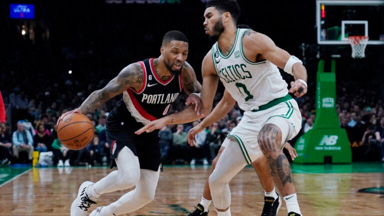 Portland Trail Blazers forward Damian Lillard, left, drives to the basket against Boston Celtics forward Jayson Tatum during the second half of an NBA basketball game, Wednesday, March 8, 2023, in Boston.