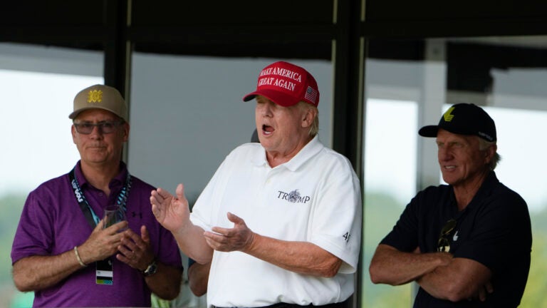 Former President Donald Trump stands next to Greg Norman, LIV Golf CEO, right, and Paul Myler, deputy head of mission for the Australian Embassy in Washington, left.