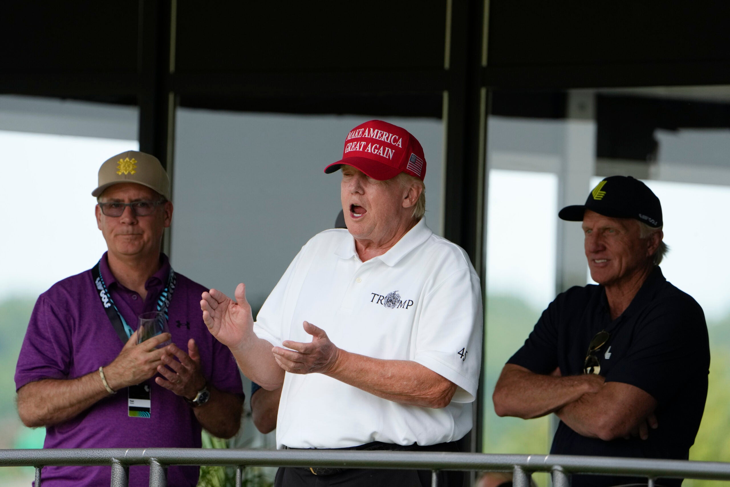 Former President Donald Trump stands next to Greg Norman, LIV Golf CEO, right, and Paul Myler, deputy head of mission for the Australian Embassy in Washington, left.