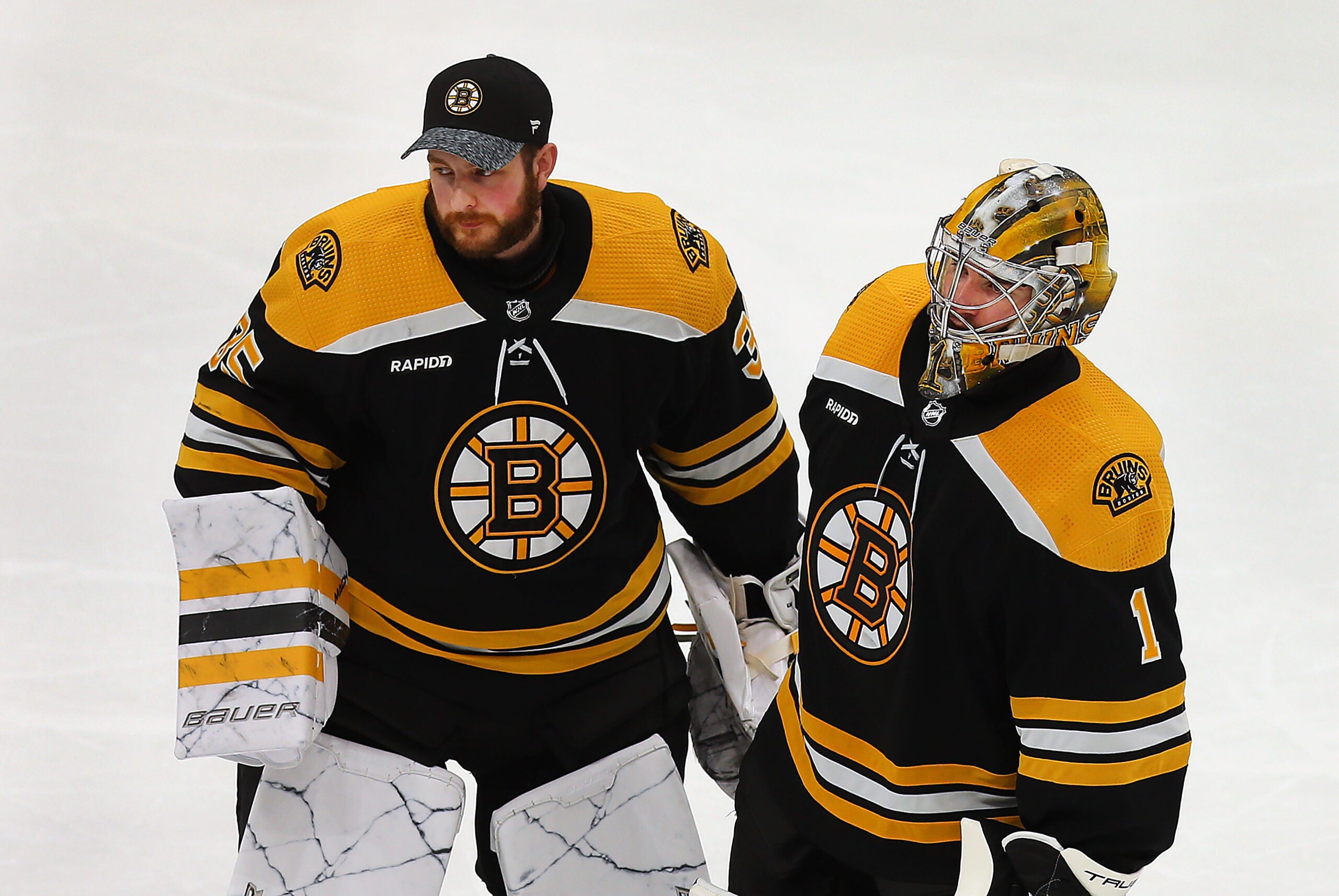 Boston Bruins goaltender Linus Ullmark (35) (left) and Boston Bruins goaltender Jeremy Swayman (1) skate to the line to shake hands of Florida players at the end of their overtime loss.