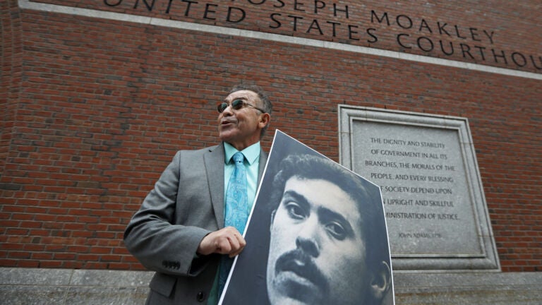 Victor Rosario holds a photo of himself at 24, when he was wrongfully convicted.
