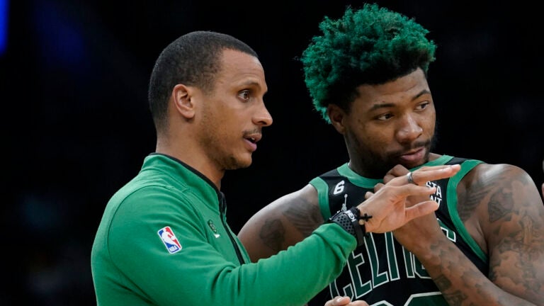 Boston Celtics interim head coach Joe Mazzulla, left, speaks with guard Marcus Smart, right, in the first half of an NBA basketball game against the Washington Wizards, Sunday, Oct. 30, 2022, in Boston.