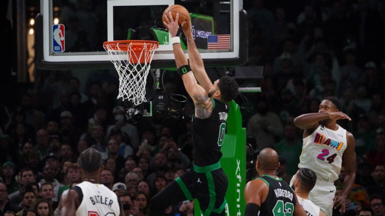 Boston Celtics forward Jayson Tatum drives for a running dunk against the Heat.