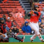 Alex Verdugo follows through on and watches his home run to right field at Fenway Park.
