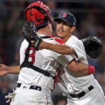 Red Sox pitcher Justin Garza celebrates the final out against the Mariners with catcher Reese McGuire.