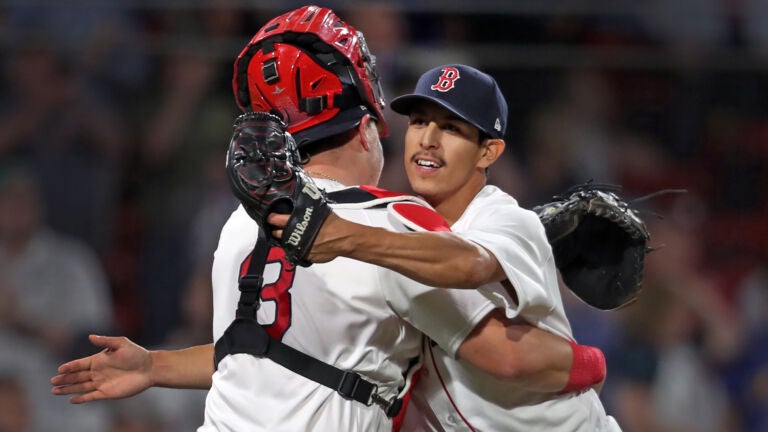 Red Sox pitcher Justin Garza celebrates the final out against the Mariners with catcher Reese McGuire.