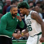Boston, MA: 05-13-22: Celtics head coach Ime Udoka (left) has a hand for Marcus Smart (right) as he comes to the sidelines.The Boston Celtics hosted the Milwaukee Bucks for Game Seven of their NBA basketball Eastern Conference Semi-Final Playoff series at the TD Garden.
