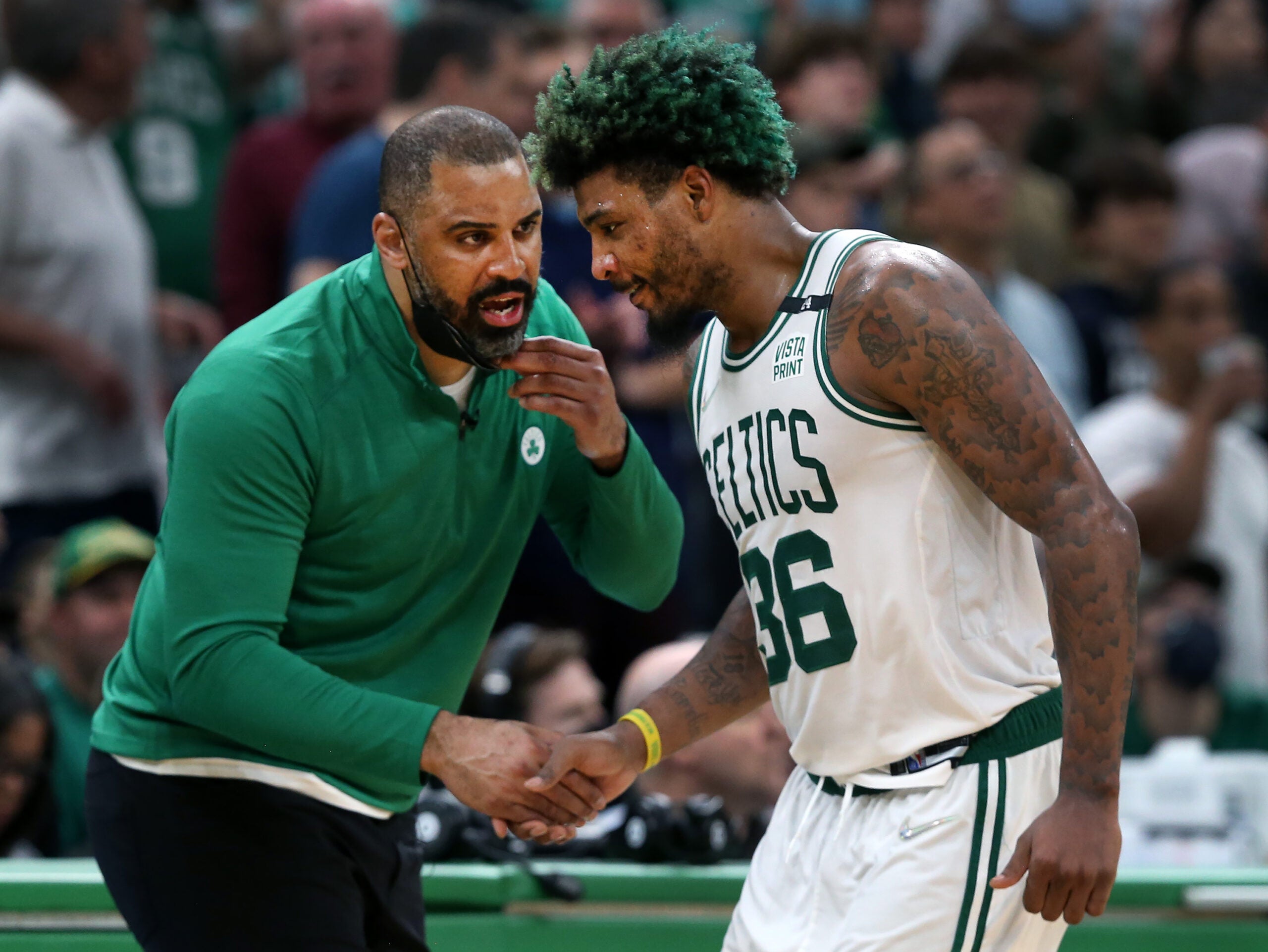Boston, MA: 05-13-22: Celtics head coach Ime Udoka (left) has a hand for Marcus Smart (right) as he comes to the sidelines.The Boston Celtics hosted the Milwaukee Bucks for Game Seven of their NBA basketball Eastern Conference Semi-Final Playoff series at the TD Garden.