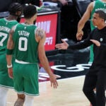 Celtics head coach Joe Mazzulla greets Jaylen Brown and Jayson Tatum as they come back to the bench.