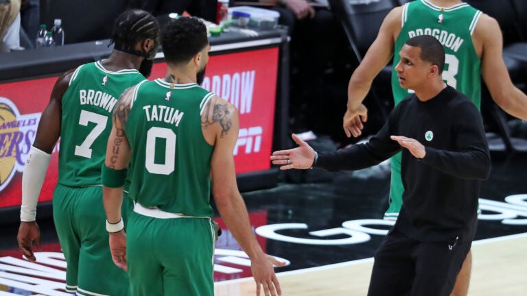 Celtics head coach Joe Mazzulla greets Jaylen Brown and Jayson Tatum as they come back to the bench.