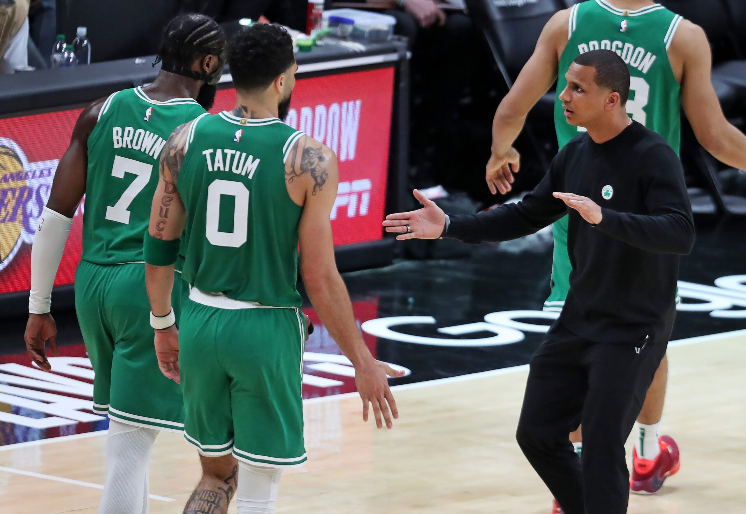 Celtics head coach Joe Mazzulla greets Jaylen Brown and Jayson Tatum as they come back to the bench.