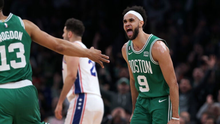 After the Celtics Malcolm Brogdon (13,left) hit a three pointer during their third quarter barrage, teammate Derrick White (right) howled with delight.