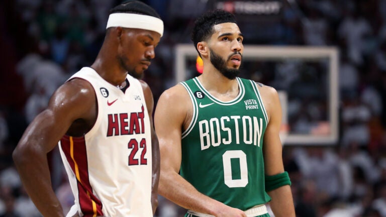 Miami's Jimmy Butler (left) and the Celtics Jayson Tatum (right) are pictured during a late fourth quarter free throw by Boston.