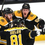 Bruinjs Tyler Bertuzzi(rt) celebrates his 3rd period goal with Boston Bruins right wing David Pastrnak (88) (left) and Dmitry Orlov.