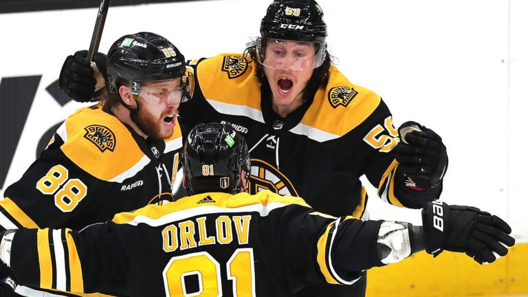 Bruinjs Tyler Bertuzzi(rt) celebrates his 3rd period goal with Boston Bruins right wing David Pastrnak (88) (left) and Dmitry Orlov.