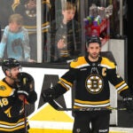 Two Bruins players watch on as the Panthers win Game 7.