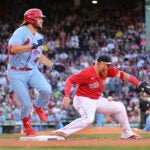Justin Turner fails to pick a bounced throw at first base as St. Louis runner hits the bag.