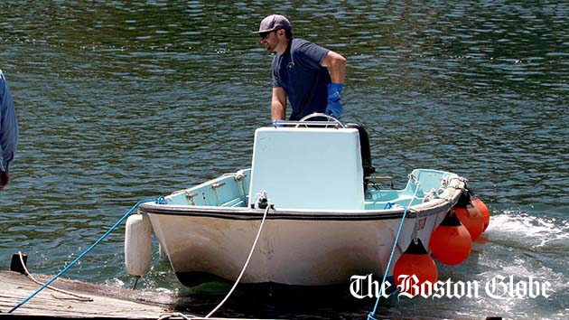 Nate Cunningham, waterfront manager of the Annisquam Yacht Club, uses the club's workskiff, a 1960 Boston Whatler, to move a float in Lobster Cove in Gloucester, Mass.