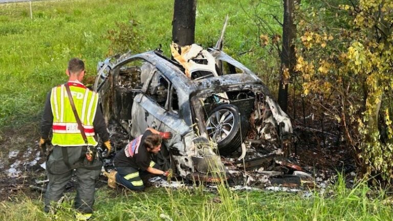 Firefighters investigate the scene of a fiery car crash on I-93 in New Hampshire.