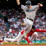 Miami's Garrett Cooper reaches first on a single as Red Sox first baseman Triston Casas misses the throw.