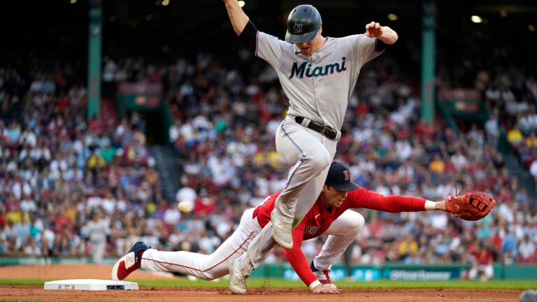 Miami's Garrett Cooper reaches first on a single as Red Sox first baseman Triston Casas misses the throw.