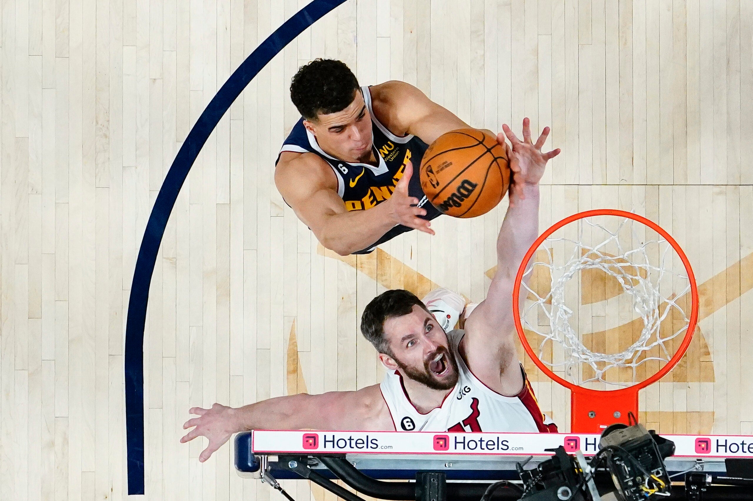 Miami Heat forward Kevin Love, bottom, reaches for a loose ball against Denver Nuggets forward Michael Porter Jr. during the second half of Game 2 of basketball's NBA Finals.