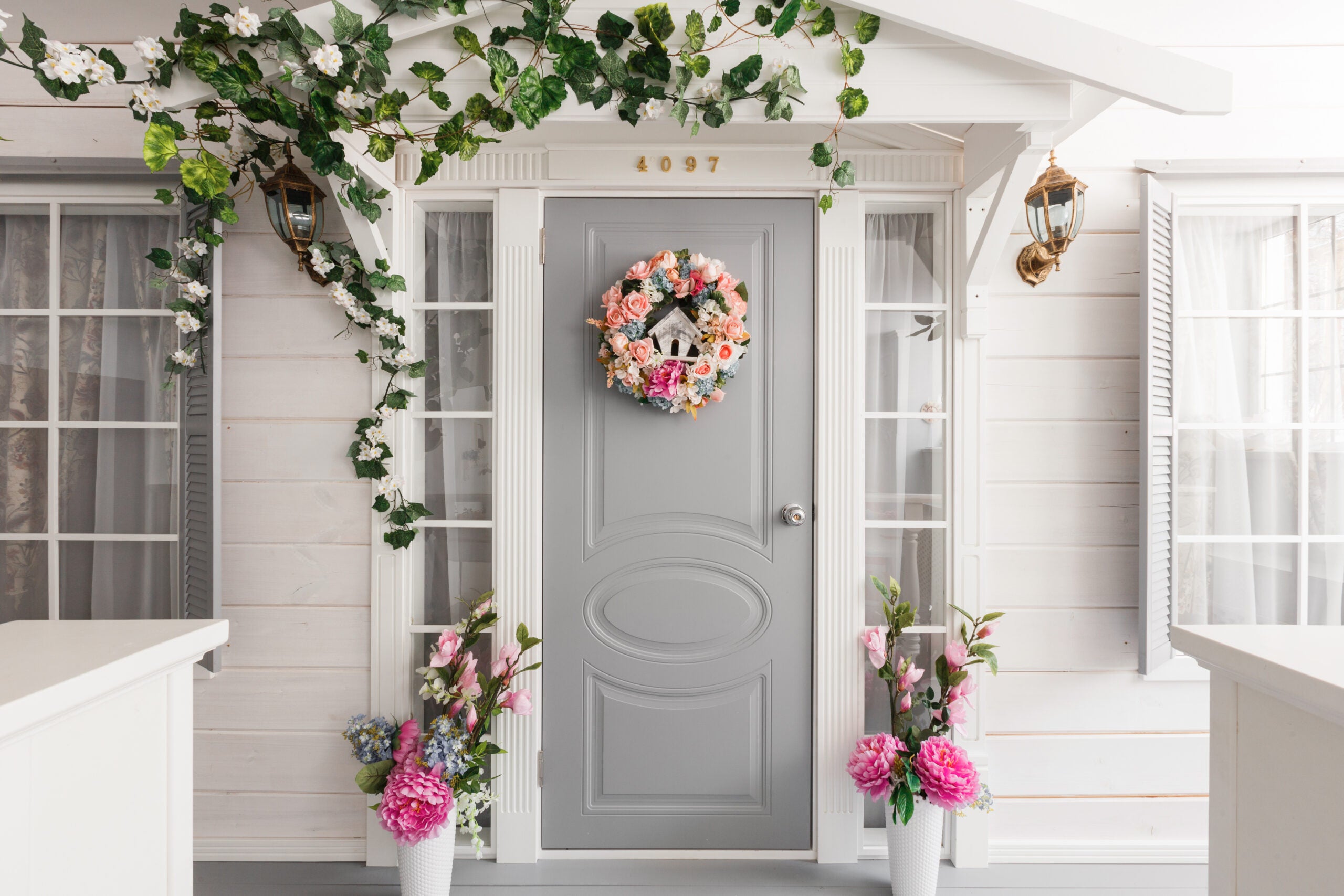 White small wooden house with gray door. spring flower decoration paint color