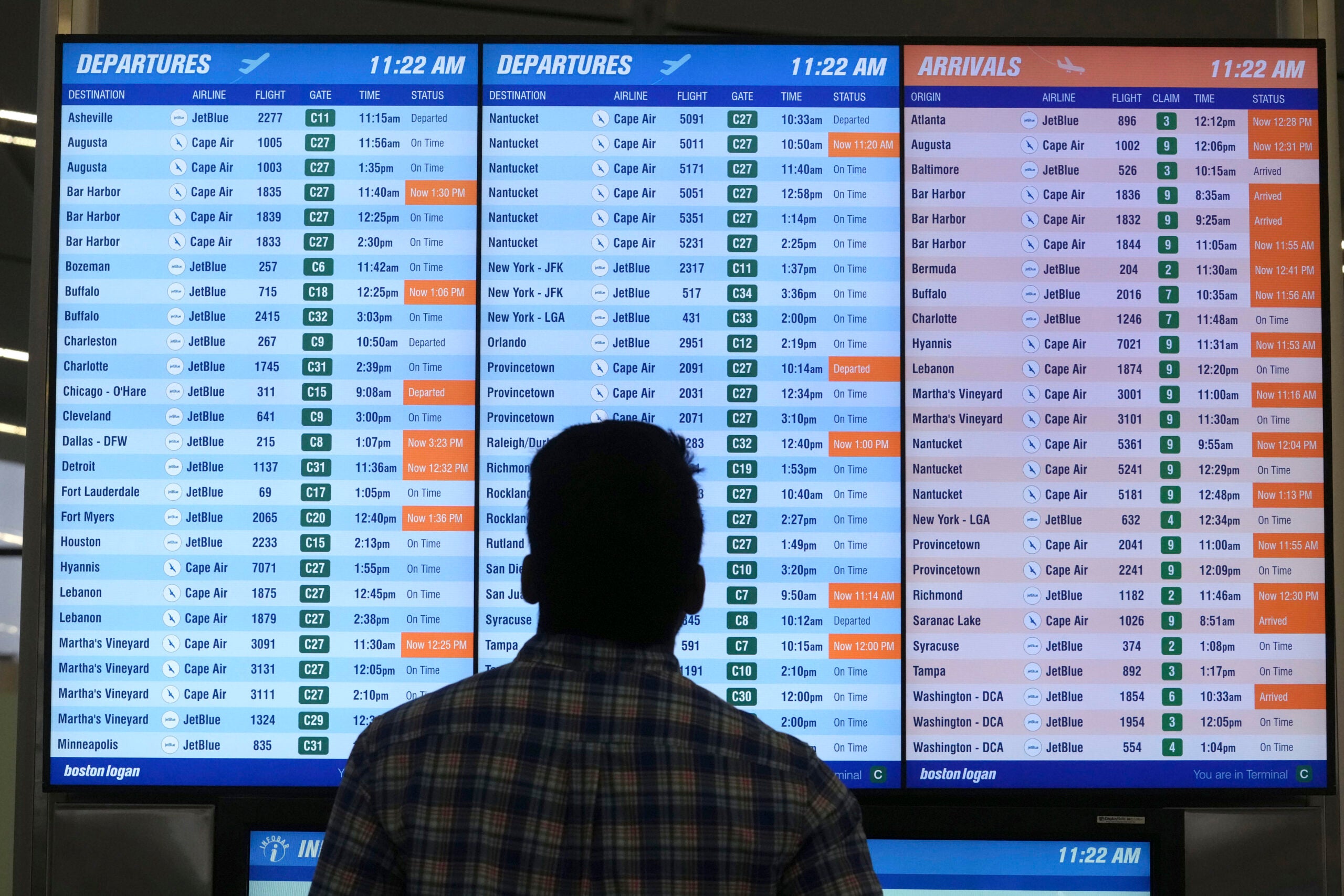 A man views a flight board at Boston Logan International Airport.