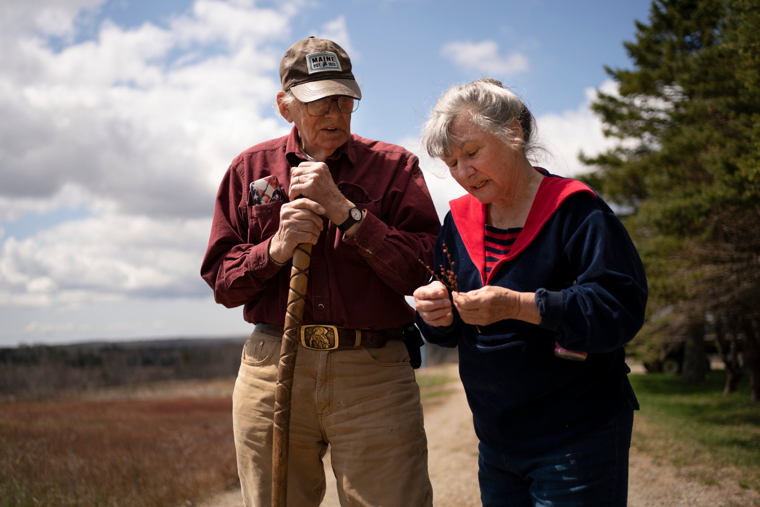 Dell and Marie Emerson examine a blueberry sprig behind their home.