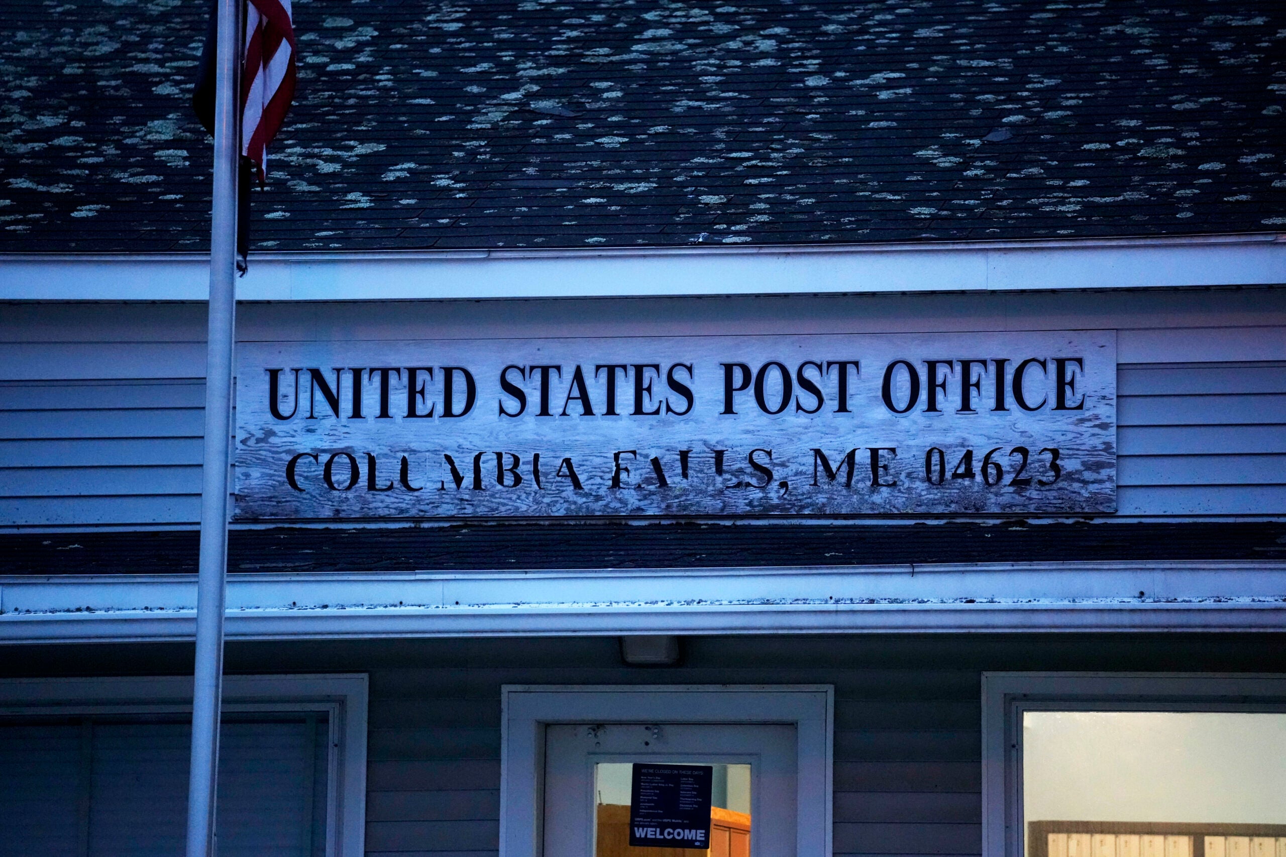 A weathered sign at the post office in Columbia Falls, Maine.