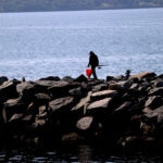 Boston weather -- A fisherman walks a jetty by Quonset Point in North Kingston RI.
