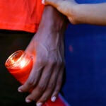Community members gather for a candlelight vigil for Branden Colvin Sr., Ryan Hitchcock and Daniel Prien outside Davenport City Hall.