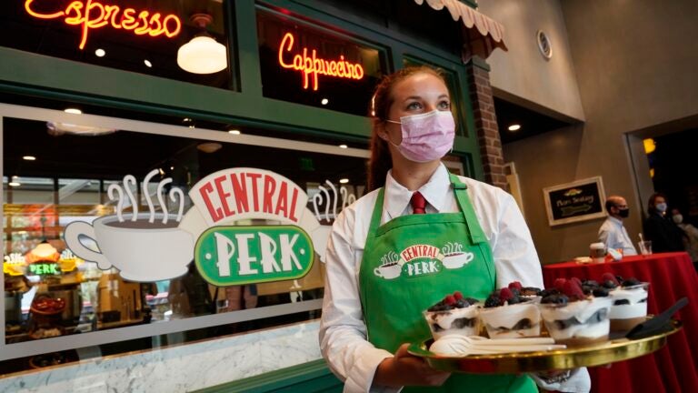 Madison Lakratz offers chocolate trifles to visitors to the "Friends"-inspired "Central Perk Cafe" at the Warner Bros. Studio Tour Hollywood media preview on June 24, 2021, in Burbank, Calif.