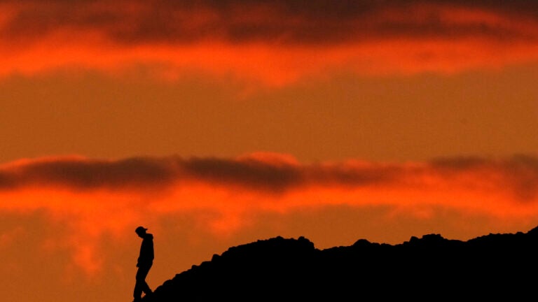 A person is silhouetted against the sky at sunset at Papago Park in Phoenix.