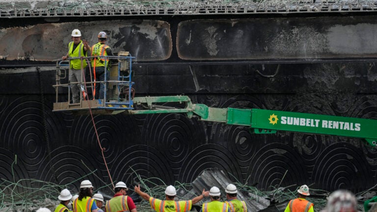 Crews work at the site of a collapsed elevated section of Interstate 95 in Philadelphia.