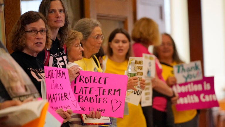 Protesters line the hallway leading to the House Chamber in Maine.