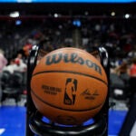 An NBA basketball sits in a rack before a game between the Detroit Pistons and the Charlotte Hornets.