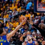 Denver Nuggets forward Michael Porter Jr., left, and Miami Heat center Bam Adebayo reach for the ball during the first half of Game 1 of basketball's NBA Finals.