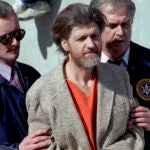 In this April 4, 1996, photo, Ted Kaczynski, better known as the 'Unabomber,' is flanked by federal agents as he is led to a car from the federal courthouse in Helena, Montana.