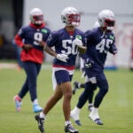 New England Patriots cornerback Christian Gonzalez (50) warms up with linebackers Matthew Judon (9) and Chris Board (45) at the NFL football team's practice facility, Tuesday, June 13, 2023, in Foxborough, Mass.