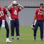 New England Patriots quarterbacks Mac Jones (10) Bailey Zappe (4) and Trace McSorley (19) warm up during an NFL football practice, Tuesday, June 13, 2023, in Foxborough, Mass.