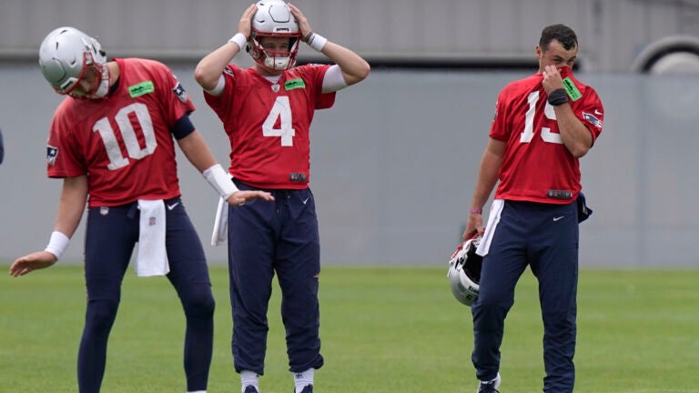 New England Patriots quarterbacks Mac Jones (10) Bailey Zappe (4) and Trace McSorley (19) warm up during an NFL football practice, Tuesday, June 13, 2023, in Foxborough, Mass.