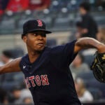 Brayan Bello, shown from the waist up, rears back to throw out of the right side of the frame.