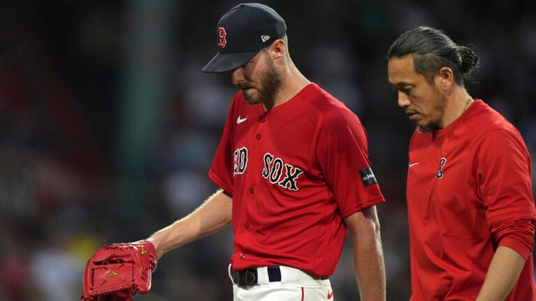 Boston Red Sox's Chris Sale, left, walks to the dugout after being removed during the fourth inning of the team's baseball game against the Cincinnati Reds, Thursday, June 1, 2023, in Boston.