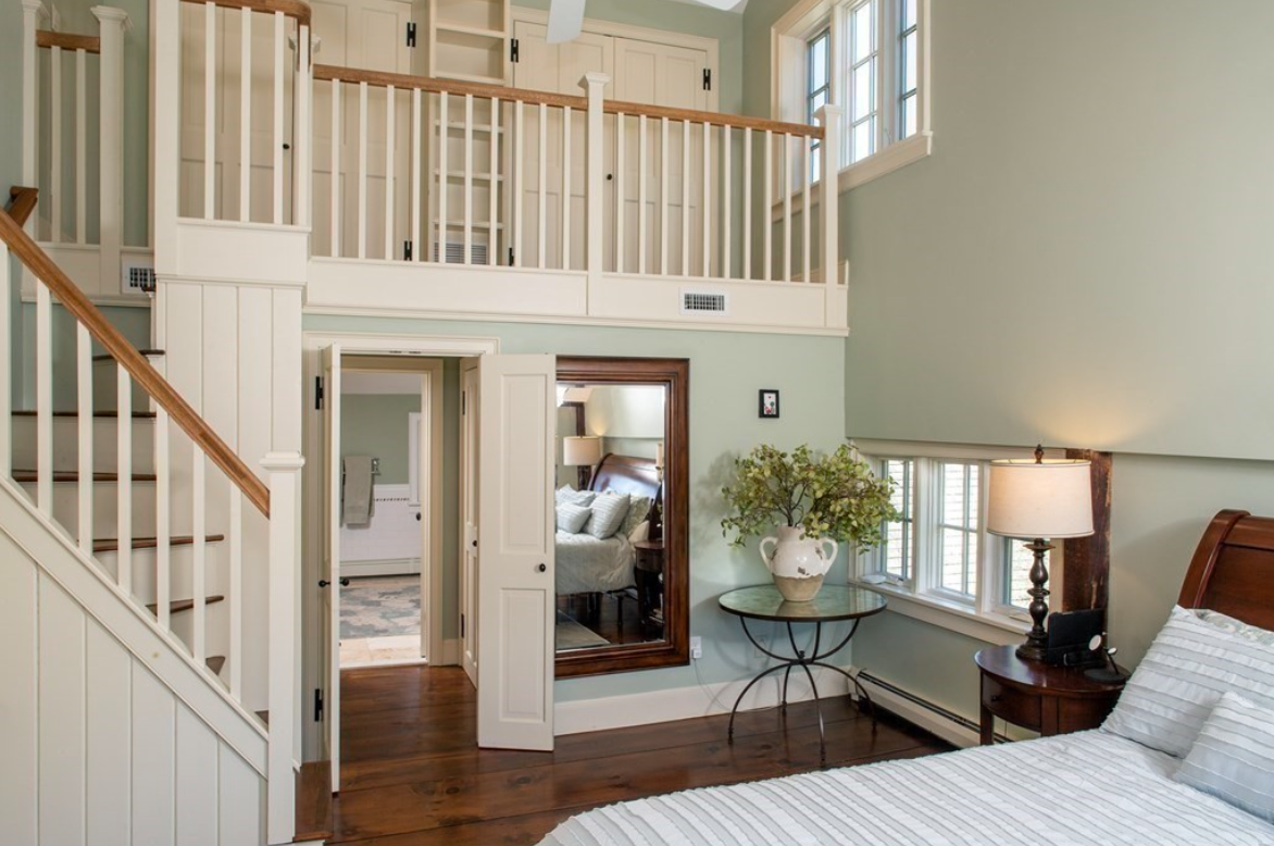 Multi-tiered bedroom with seafoam green walls and white trim.