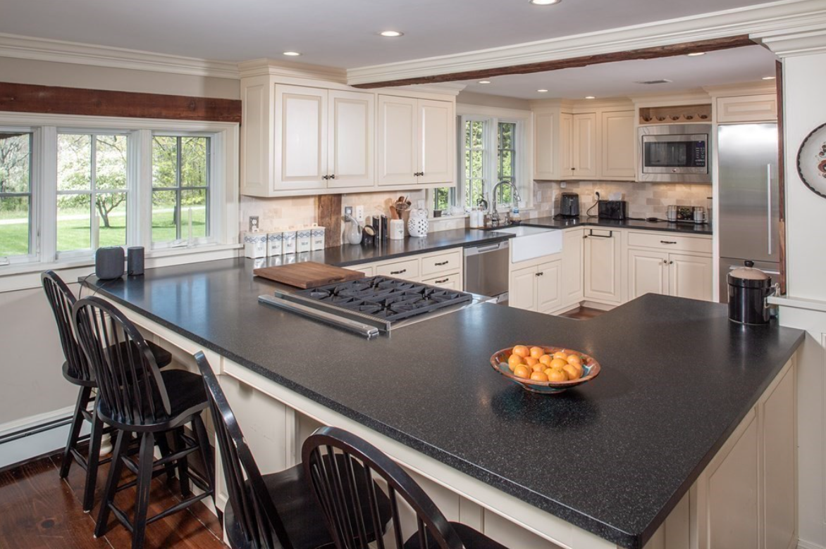 Kitchen with white raised-panel cabinets, stainless steel appliances, and single-hung windows.