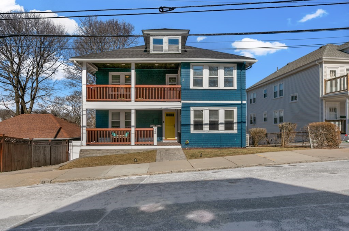 Condo with blue exterior and two-level front porch with baluster railings.