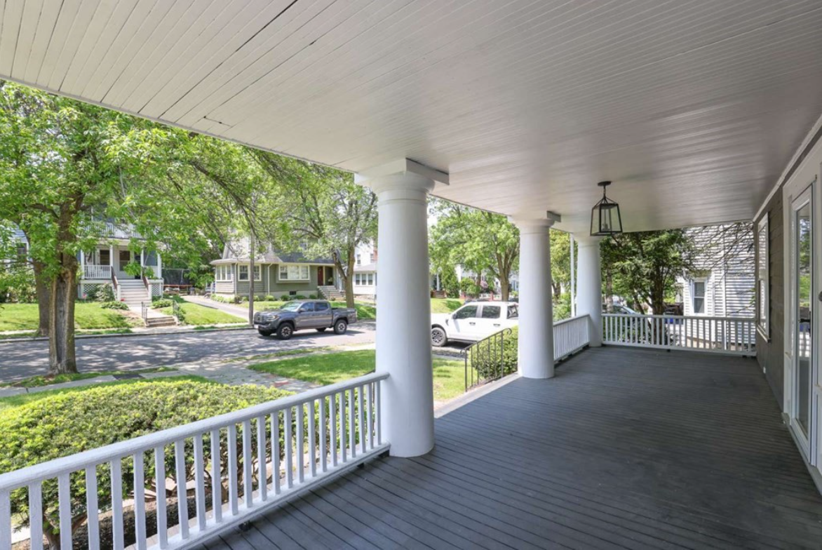 Front porch with white columns and railing.